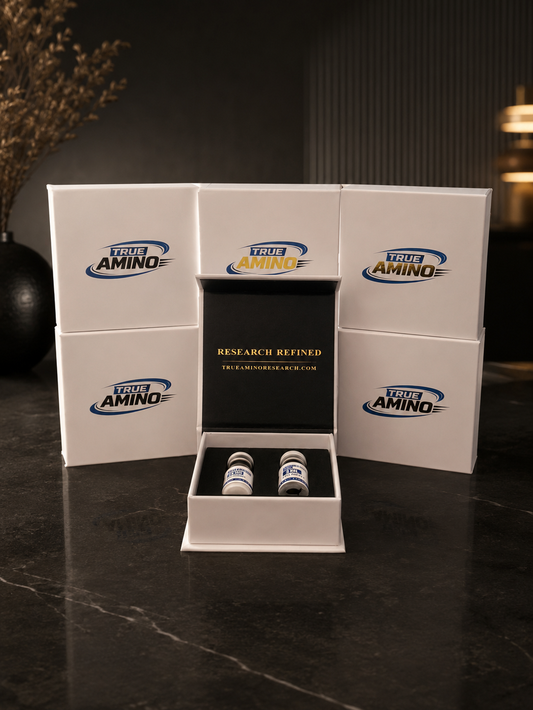 True Amino research peptide packaging set in a dark studio setting